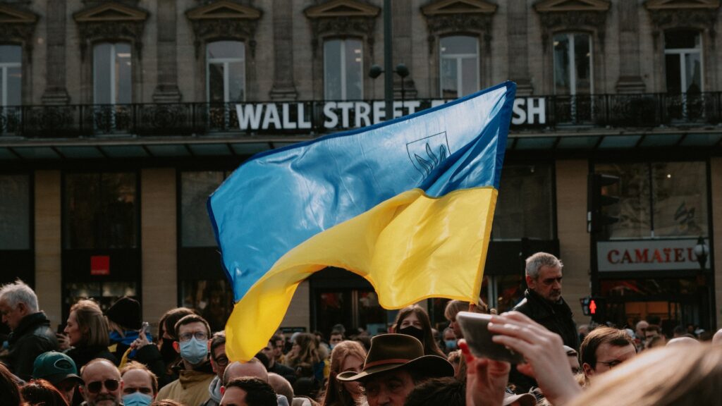 Eine Ukraine Flagge gehisst in einer großen Menschenmenge